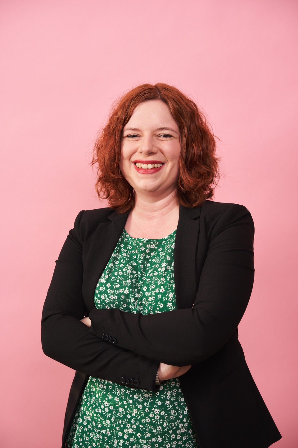 Portraitfoto von Lisa Dziobaka vor einem rosafarbenem Hintergrund.