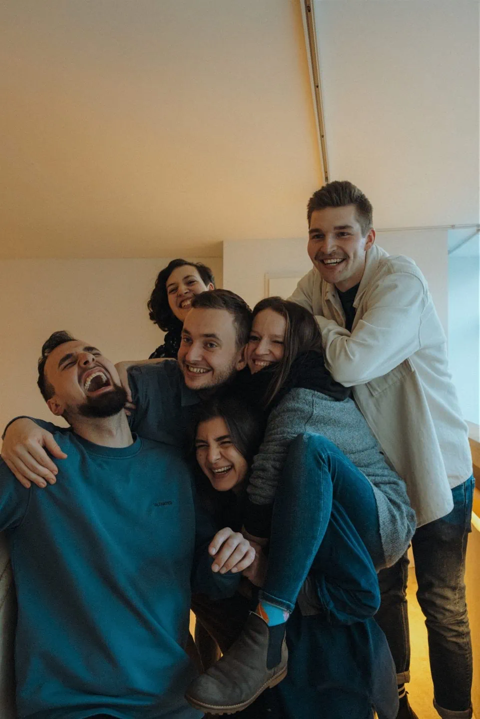 Hamburger Fellows, die gemeinsam ein Lerncamp organisiert haben, stehen zusammen auf einer Treppe und umarmen sich lachend uns stürmisch.