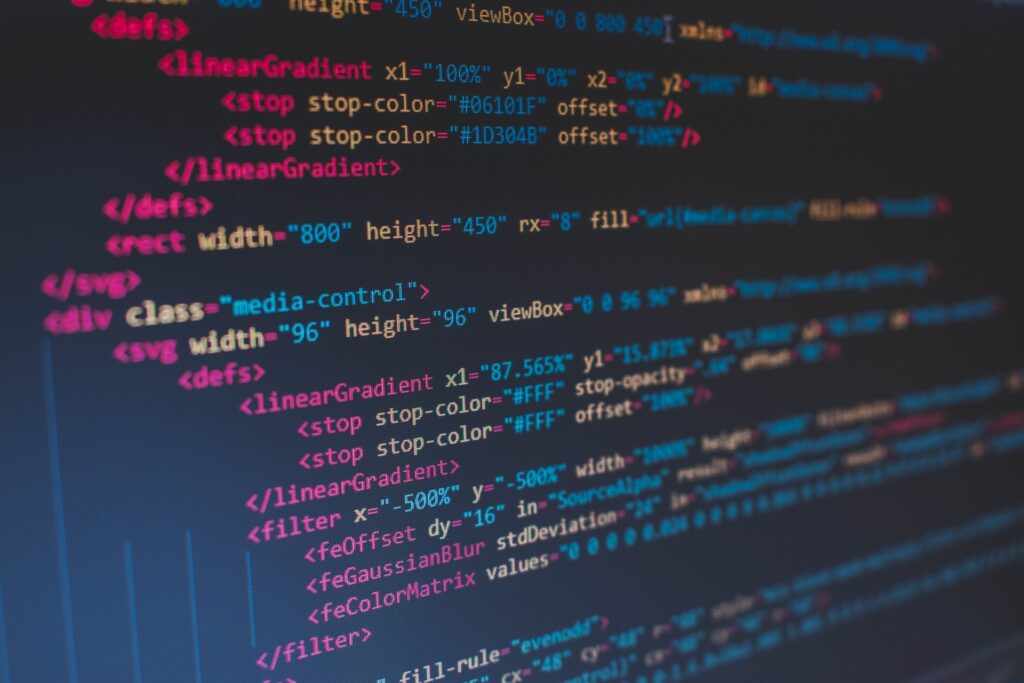 Foto eines Coding-Editors, in dem Codetext auf schwarzem Hintergrund bunt eingefärbt ist. Credit: Florian Olivo auf Unsplash