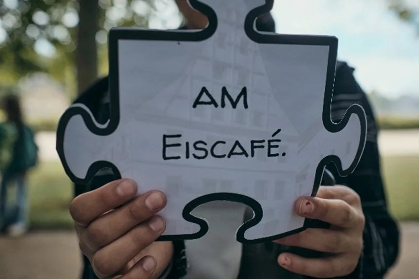 Schüler hält ein Puzzleteil der Stadtrallye